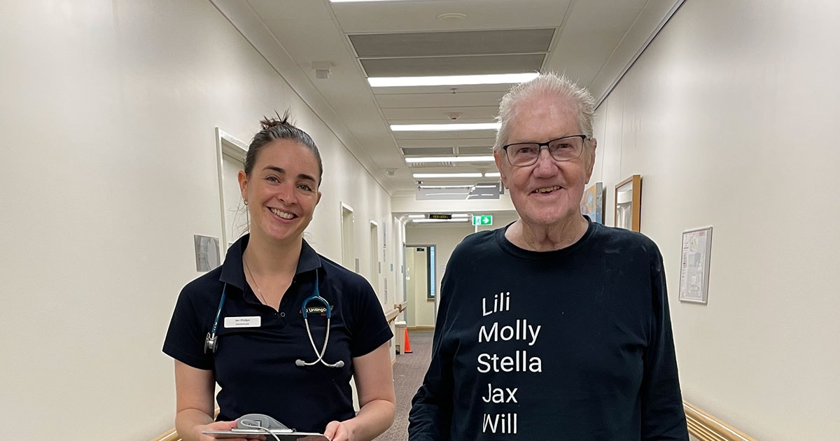 The Wesley Hospital staff member and patient standing in hallway smiling at camera