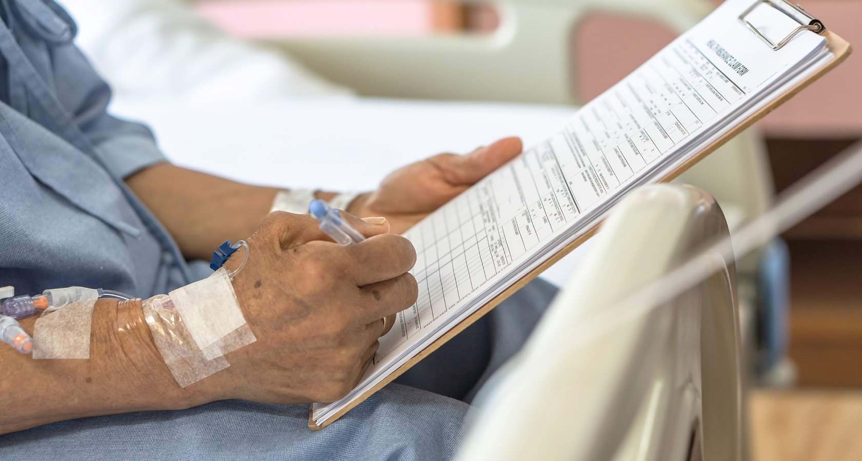 A patient writing on a clipboard