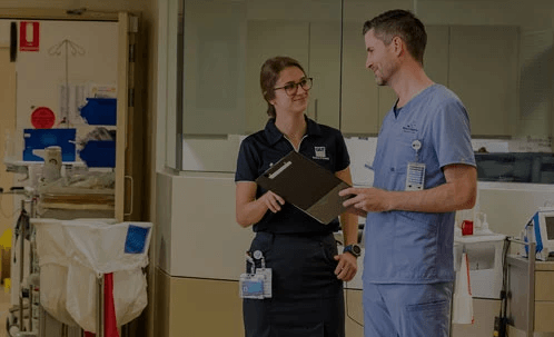 Be focused – A young Graduate Nurse Program participant talks with a doctor in a Wesley Hospital corridor.