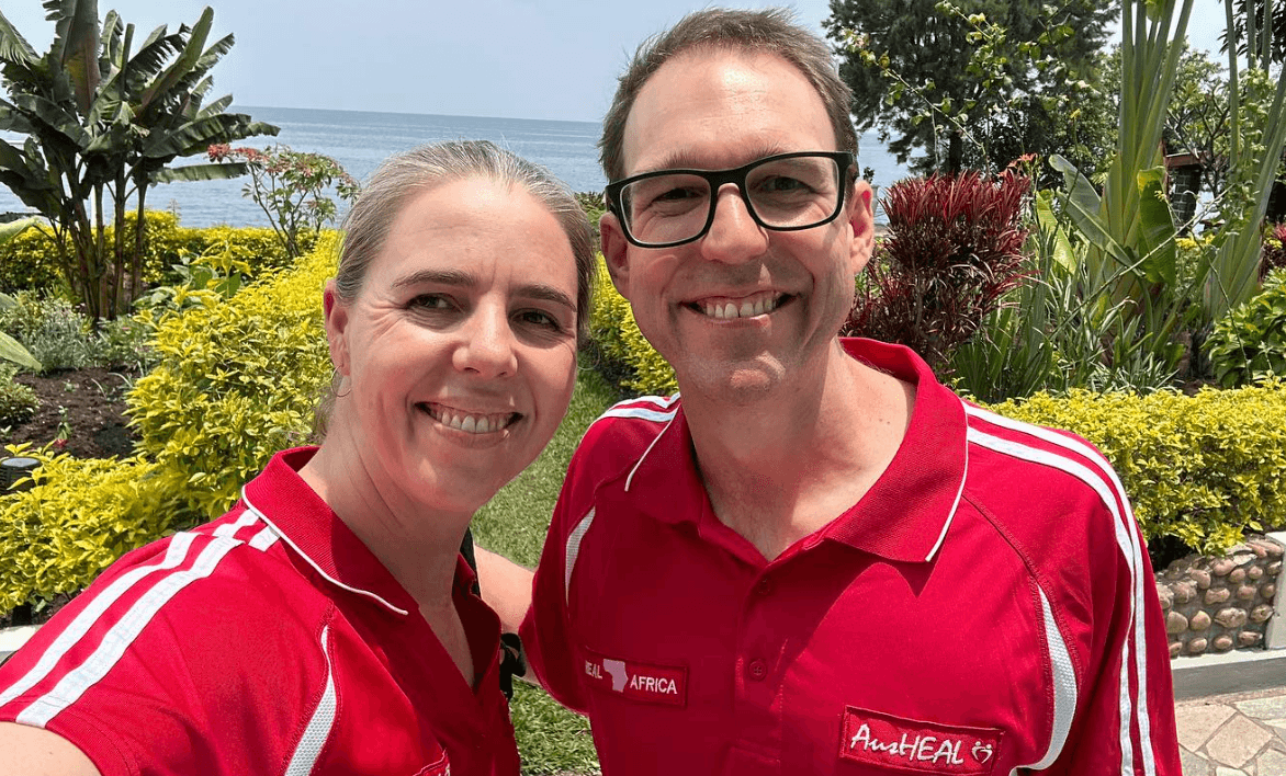 DRC doctors Doctors Heywood in red polo shirts standing in front of a tropical garden