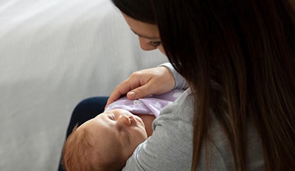 Mother holding newborn child in swaddle